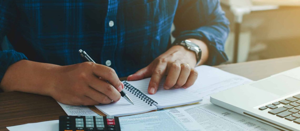 Man doing finances and calculate about cost to real estate investment and in other, tax system.Time for Taxes Money Financial Accounting Taxation Concept