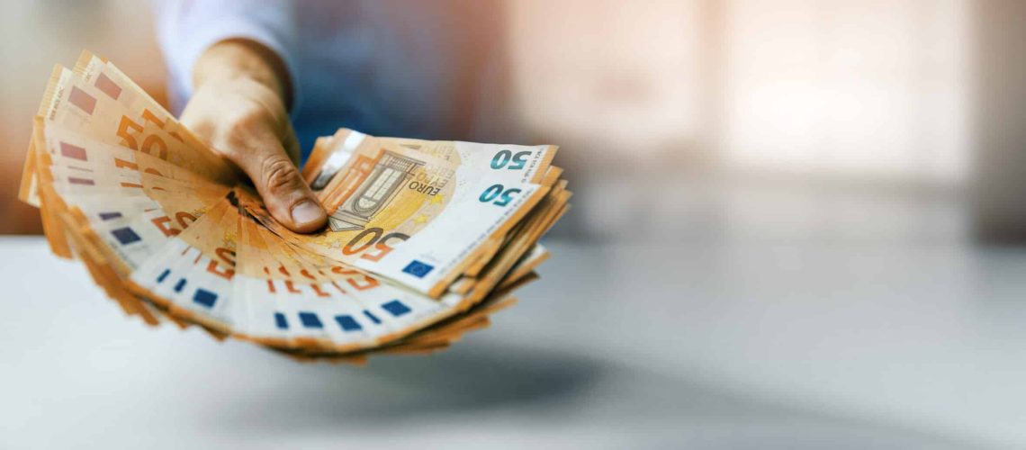 hand gives euro money banknotes. bank credit, consumer loan or lottery prize concept. banner with copy space