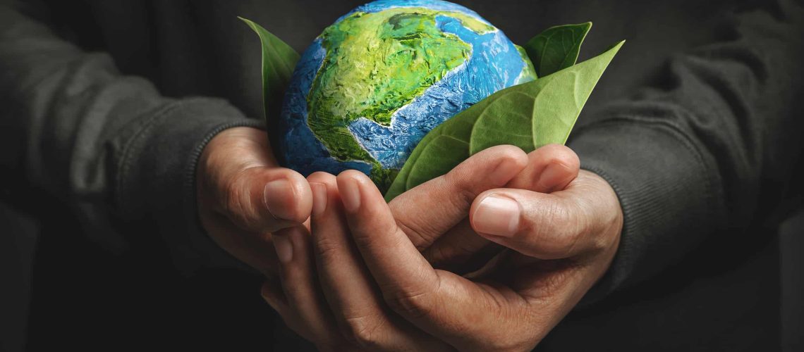 World Earth Day Concept. Green Energy, ESG, Renewable and Sustainable Resources. Environmental and Ecology Care. Hand Embracing Green Leaf and Handmade Globe