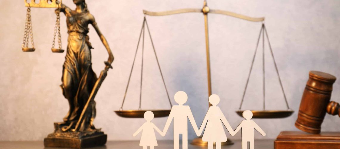 Alimony. Figures of family, scales, wooden gavel and statue of Lady Justice on table
