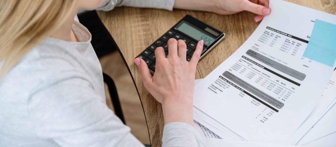 Busy woman working at home office calculating and paying utility bills for house rent. Managing finances or taxes, personal family budget planning. Accounting concept