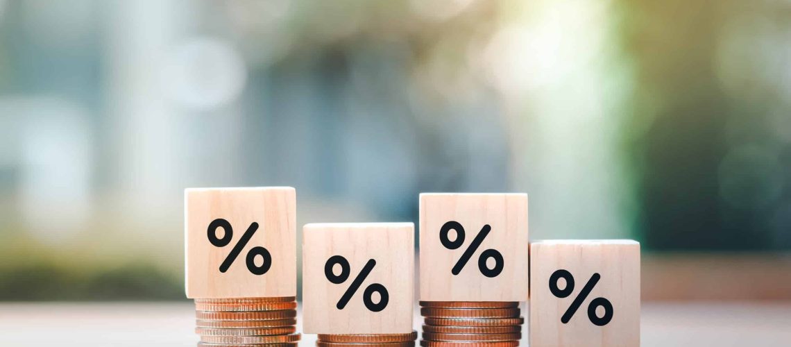 Interest rate finance and mortgage rates. Wooden block with percentage sign on many level of stack of coin. Financial growth, interest rate increase, inflation, sale price and tax rise concept.